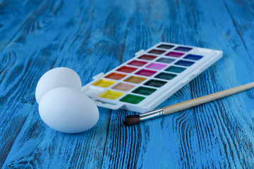 Watercolor paint, brushes and eggs. Easter eggs painting