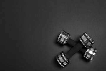 Dumbbells and blank space for exercise plan on dark background. Flat lay composition