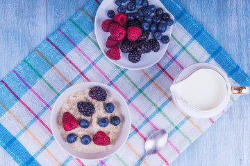 Oatmeal porridge with berries on a rustic napkin - top view