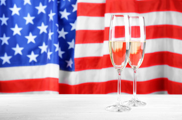 Glasses of champagne on table against flag of the USA