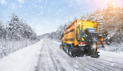 Snowplow truck removes snow on the winter road