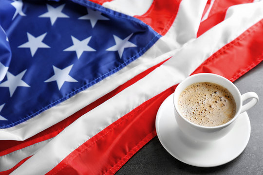 Cup of hot coffee with flag of the USA on dark background