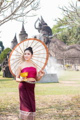 Obraz premium Beautiful Lao girl in laos costume holding umbrella.