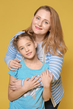 Portrait of happy mother and daughter on color background