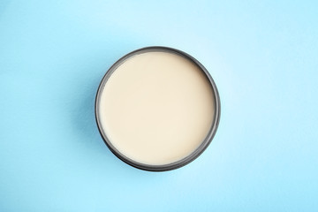 Jar with clay for hair on color background