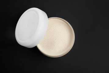 Jar with clay for hair on dark background