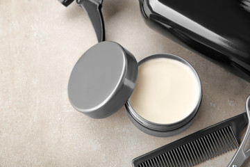 Professional hairdresser's tools and clay for hair on grey background