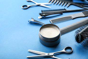 Professional hairdresser's tools and clay for hair on color background