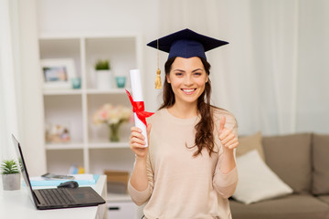 student with diploma at home showing thumbs up - obrazy, fototapety, plakaty