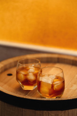 Glass of whiskey on wooden background close up