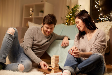 happy couple playing block-stacking game at home