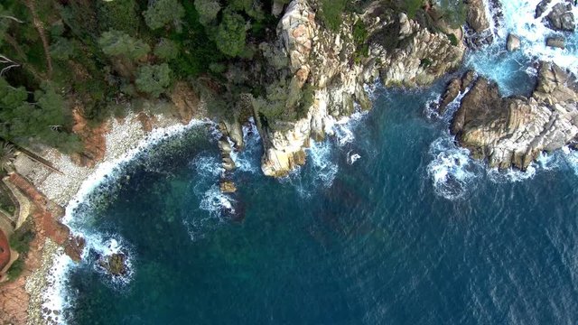 Aerial views of a coastline with waves and rocks in the Mediterranean