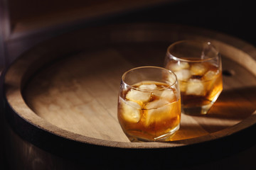 Glass of whiskey on wooden background close up