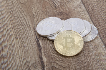 Silver bitcoins and one gold on a table