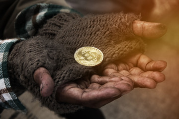 Beautiful hand homeless man holding gold bitcoin close up