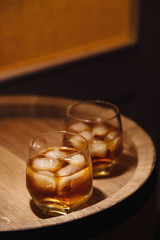 Glass of whiskey on wooden background close up
