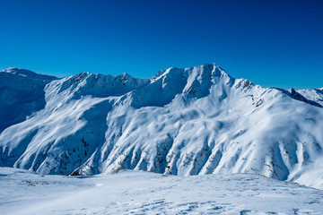 Fototapeta na wymiar Tief verschneite Berggipfel in den Alpen im Winter