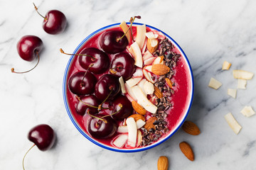 Smoothie bowl with black cherries, coconut flakes