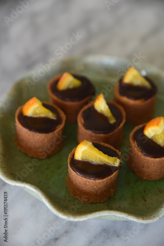 Miniature Chocolate And Orange Desserts In Decorate Plate Close
