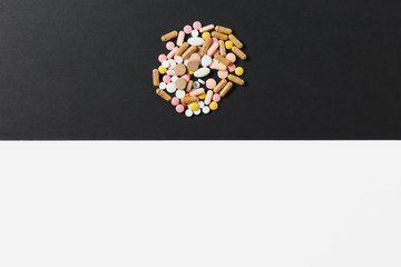 Medication white colorful round tablets arranged abstract on white black background. Aspirin, capsule pills design. Health, treatment, choice healthy lifestyle concept. Copy space for advertisement.
