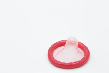 Pink condom isolated on white background, sex and valentine concept.