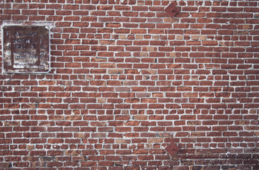 Worn no parking sign on redbrick wall