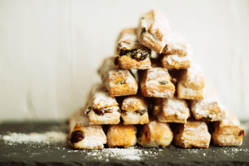 Strudel Apple and sugar powder. Biscuit from the puffed Test on the Gray Background. Dessert with Fruits.Copy space for Text. selective focus.