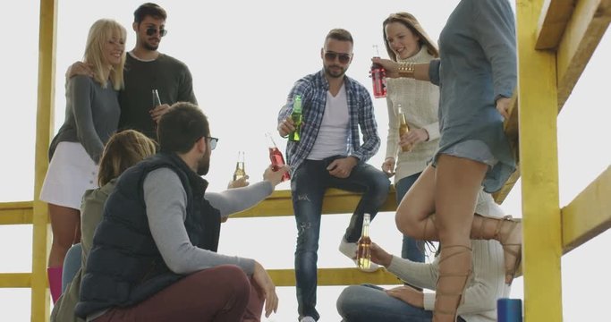 hipster friends on vacations relaxing and drinking beer at beach party
