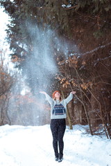 beautiful girl in a fur vest walks in a field in the snow