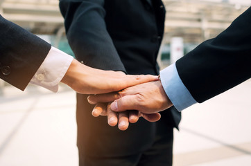 close up hand of group of three business man team joining hands together in the modern city, team...
