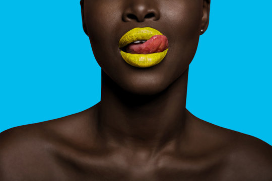 concept of colors with black skin afro woman mouth with tongue out, having orange lipstick
