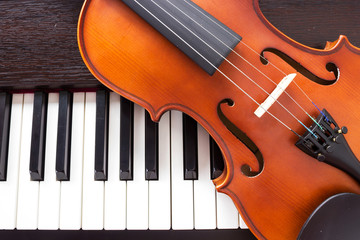 Violin on piano keyboard. Music background. Top view.