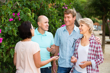  Portrait of mature males and females talking outdoors