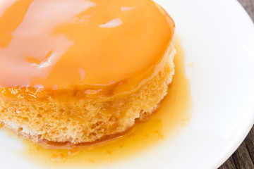 Closeup homemade caramel custard cake on white plate. French dessert.
