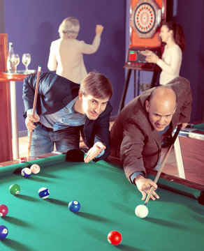 Group of friends playing billiards