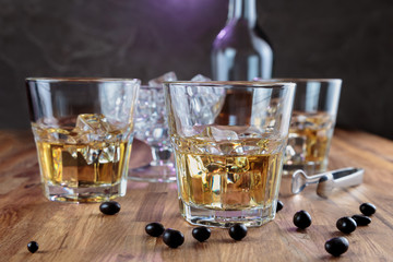three glasses of whiskey on the oak surface of the table
