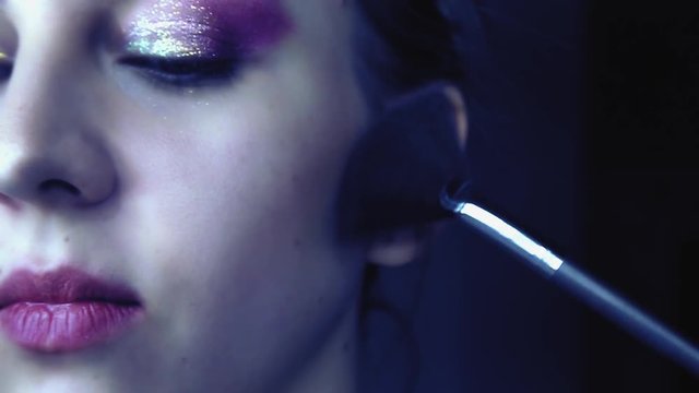 Use makeup on a beautiful woman in slow motion