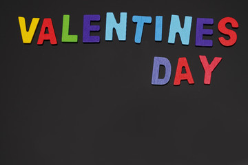 colorful wooden valentines day alphabet on the dark background