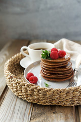 Homemade pancakes decorated with fresh raspberries. Wholemeal flour with cocoa and nut paste
