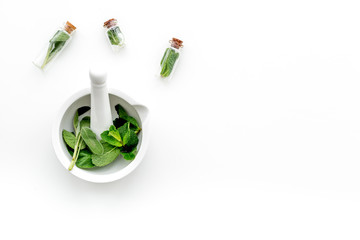 Herbal medicine. Herbs in mortar bowl and in small bottles on white background top view copy space