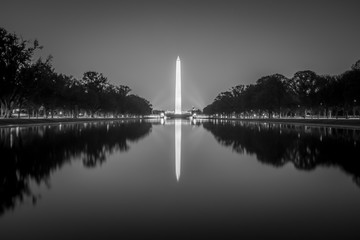 washington memorial tower reflecting in reflective pool at sunset