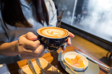 Business women hold cup of coffee latte