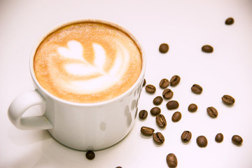 coffee with heart pattern on foam and coffee beans
