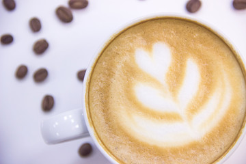 coffee with heart pattern on foam and coffee beans