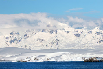 Antarctic ocean, Antarctica. Glacier Snow Covered Mountain. Dramatic blue Sky background