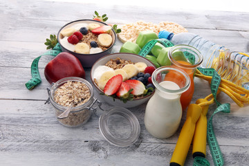 muesli with dairy and fruit, healthy lifestyle. bowl of cereal, fruit and dumbbell