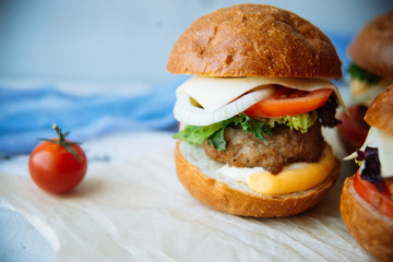 The traditional hamburger Patty, cheese, tomato, lettuce, beef Burger, takeaway. Dark wooden background, horizontal shot.