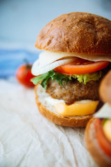 Tasty turkey burgers with corn salad and carrot,mixed seeds served on old board on a rustic wooden table with copyspace.