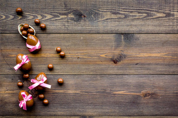 Chocolate Easter eggs on dark wooden background top view copy space