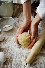 Fototapeta premium Female hands make dough for biscuit or pie 